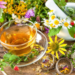 Cup of herbal tea with wild flowers and various herbs